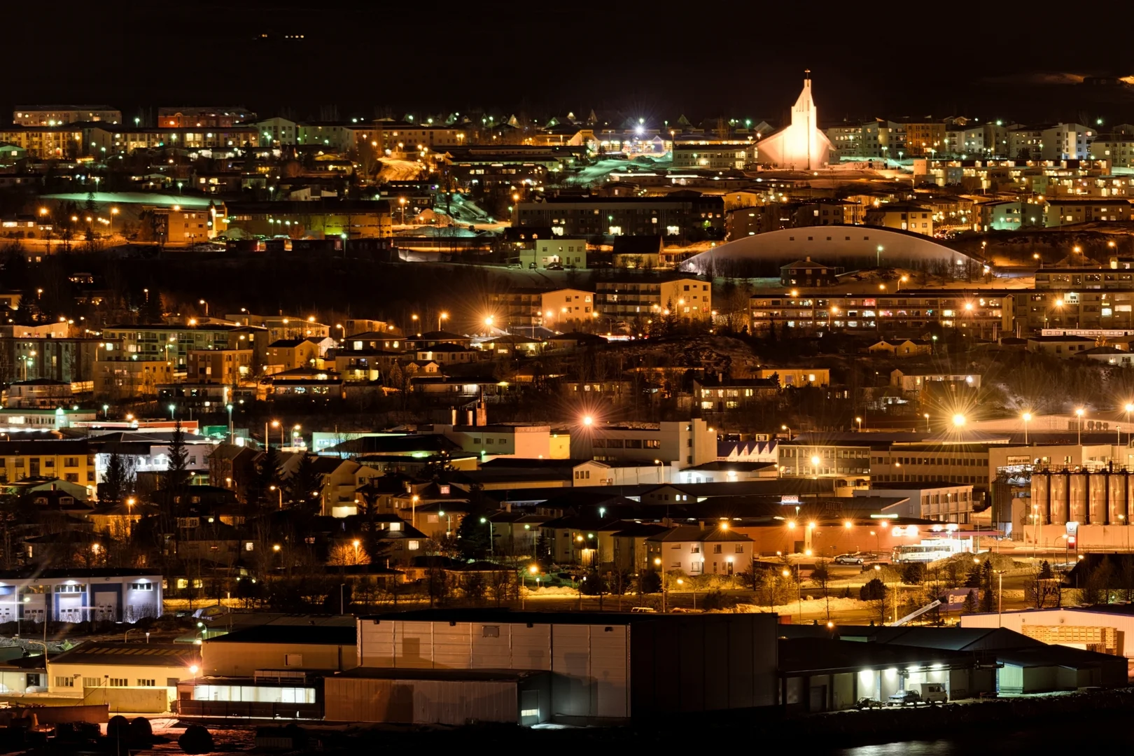 une vue nocturne de la ville illuminée, avec les lumières se reflétant